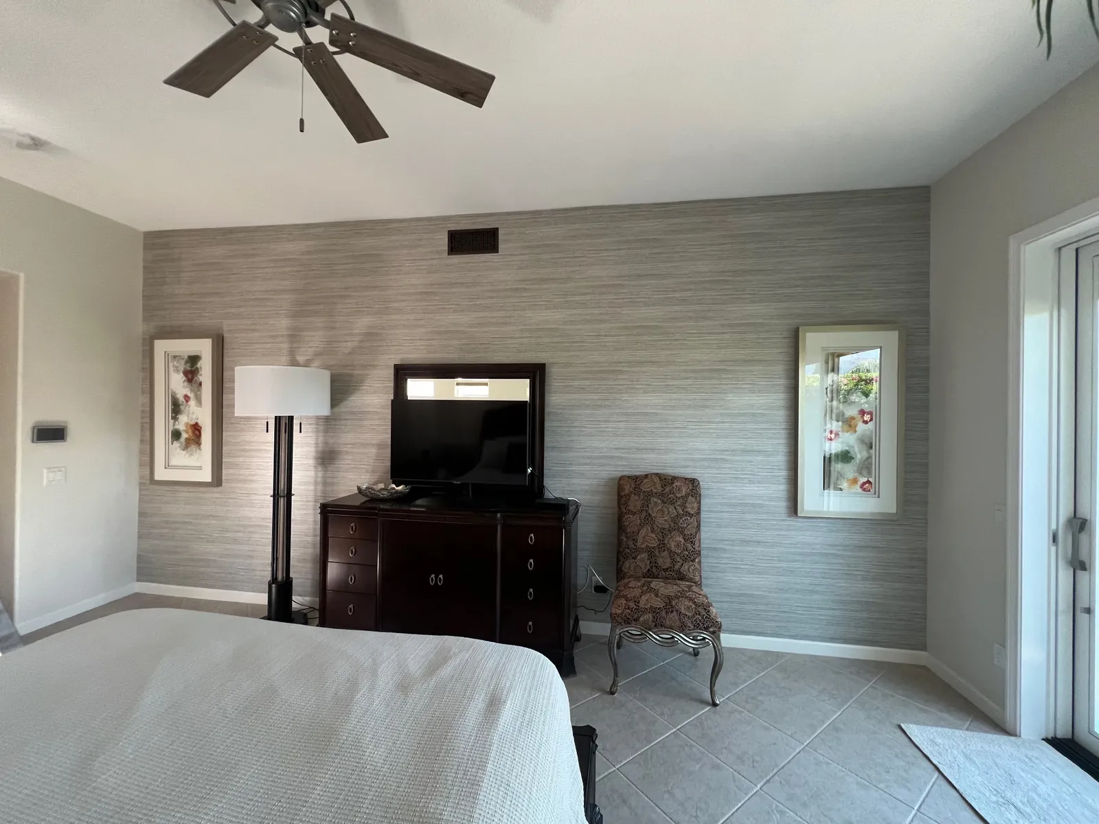 Silver faux grasscloth wallpaper installed on a bedroom accent wall, wrapped tight to the corners