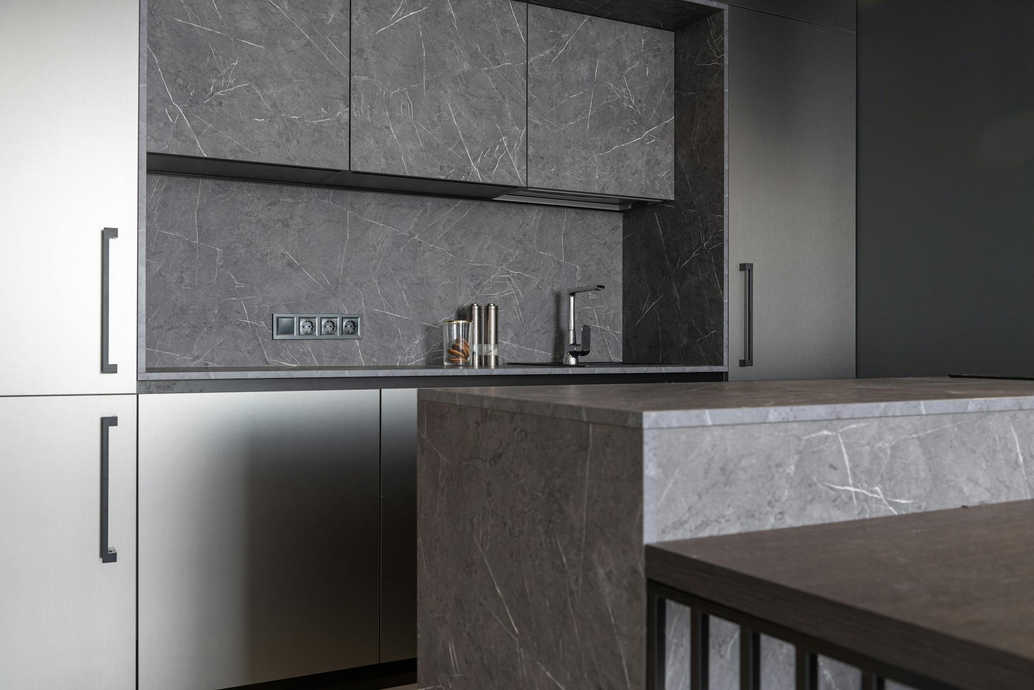Sleek modern kitchen with gray marble surfaces and minimalist design.