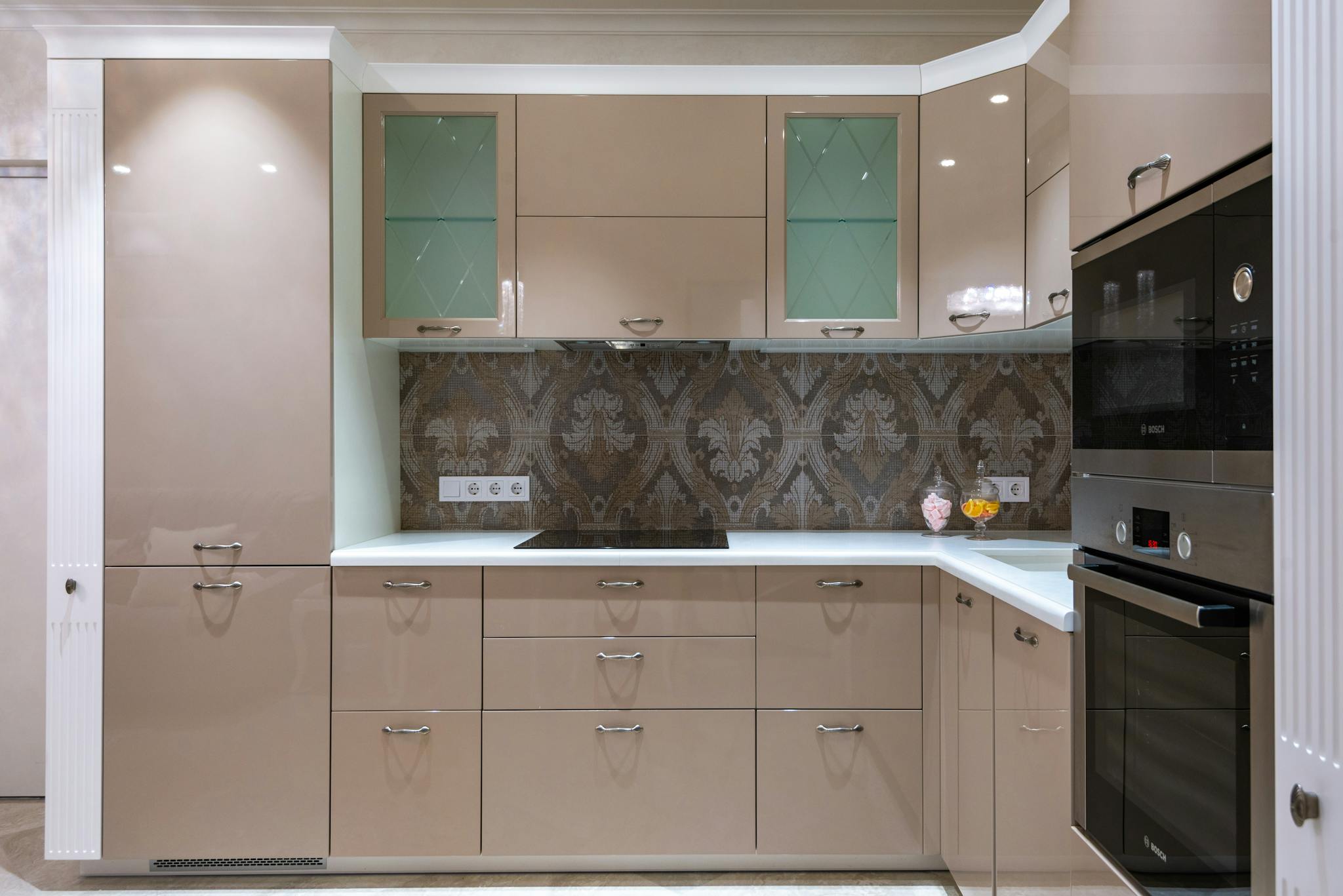Stylish and spacious modern kitchen with beige cabinets and built-in appliances, showcasing contemporary design.